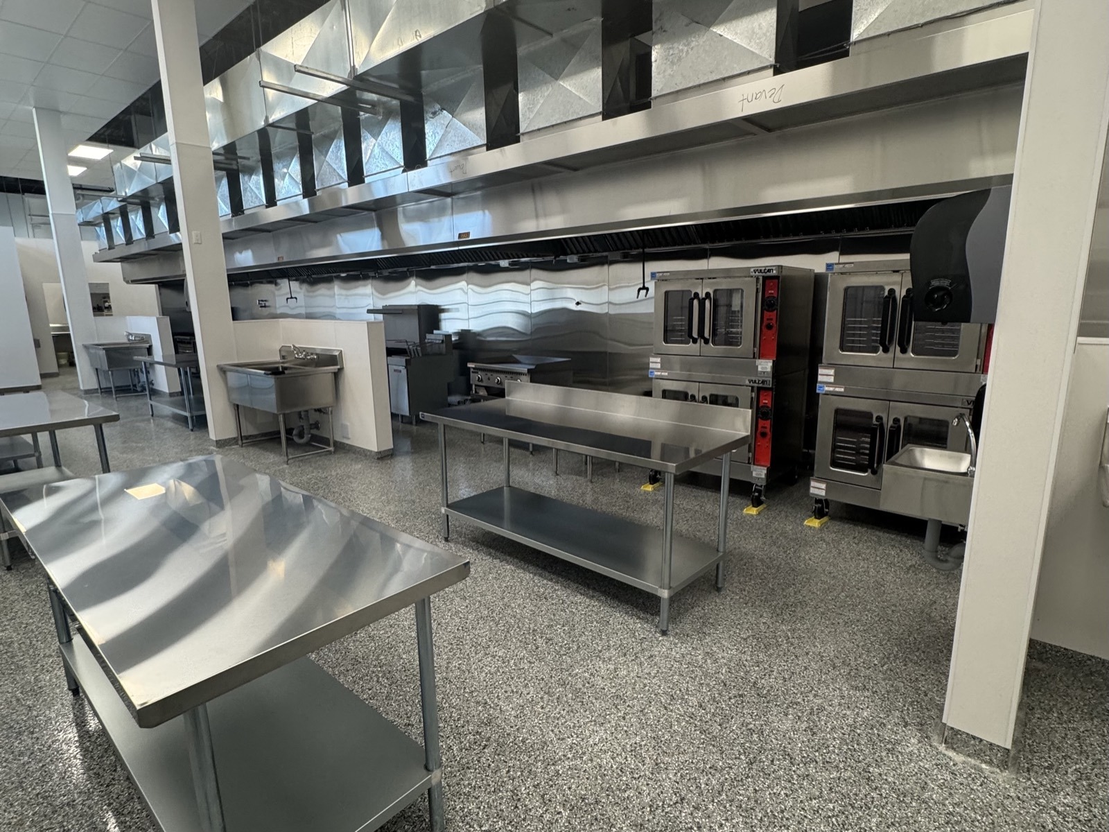 Stainless prep tables and stacked commercial convection ovens at PurePrep Langley commissary kitchen