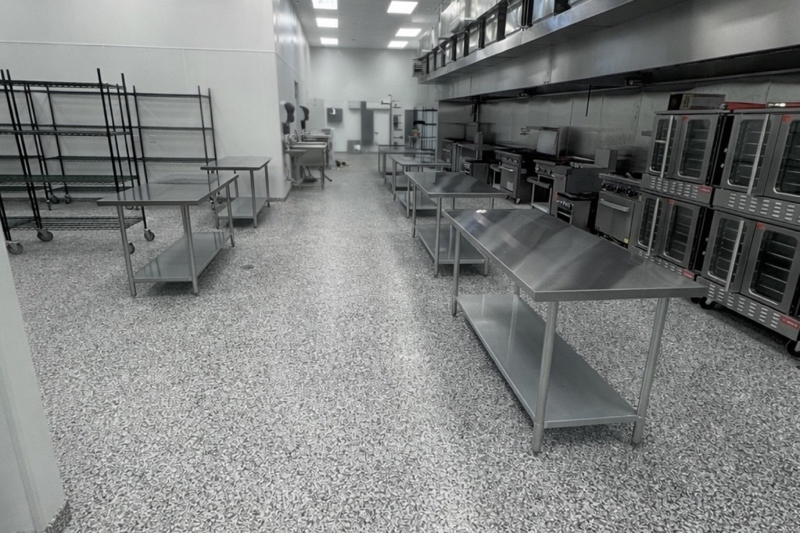 Main production floor with prep tables and commercial ovens at PurePrep’s commissary kitchen near Victoria