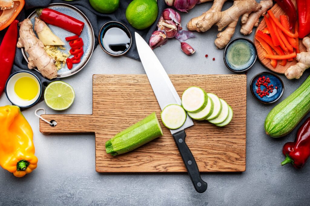 Food and cooking background. Gray table with chopped zucchini. Paprika, vegetables, spices