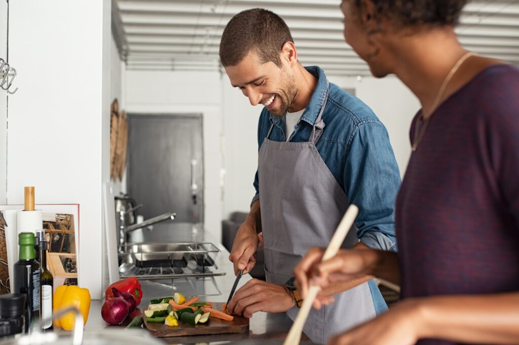 Happy couple cooking in kitchen