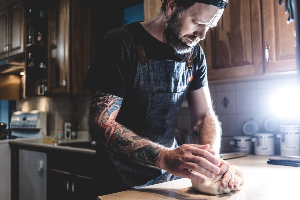 Man kneading dough on kitchen